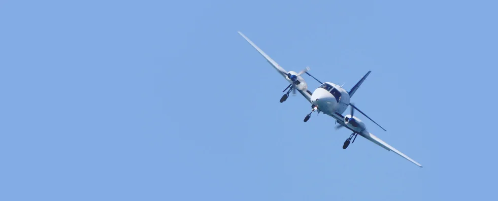Einmotoriges Flugzeug im Steigflug vor blauem Himmel